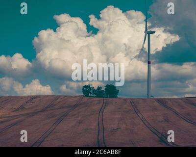 Centrale éolienne turbines sur un champ vert sous le ciel avec des nuages au coucher du soleil. Énergie verte, sources renouvelables, sauver la planète. Banque D'Images