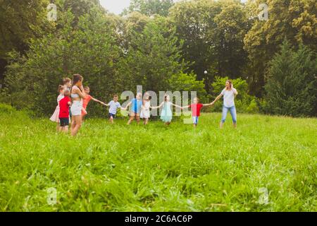 Les enfants et un enseignant s'amusent dans le parc Banque D'Images