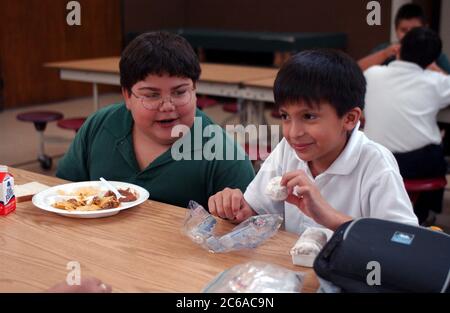 Austin Texas États-Unis, novembre 2003 : salle à manger à l'école primaire catholique paroissiale privée, montrant des garçons avec différents types de corps. ©Bob Daemmrich Banque D'Images