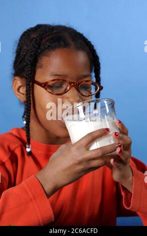 Austin, Texas, États-Unis, décembre 2003 : une fille afro-américaine de 10 ans boit un verre de lait à la maison. MR ©Bob Daemmrich Banque D'Images