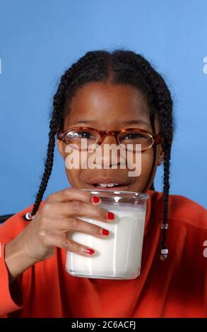 Austin, Texas, États-Unis, décembre 2003 : une fille afro-américaine de 10 ans boit un verre de lait à la maison. MR ©Bob Daemmrich Banque D'Images