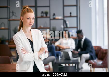 Belle femme avec un cheveu rouge regardant la caméra, posant à la caméra. Groupe international de partenaires commerciaux Banque D'Images