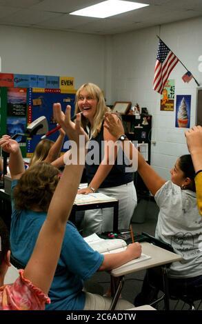 Mabank, Texas, États-Unis, 10 septembre 2003 : une enseignante dans un collège public dirige des cours de mathématiques pour les élèves de septième année. Les étudiants enthousiastes lèvent la main pour répondre à une question. VERSIONS DU MODÈLE SP-71 À SP-80. ©Bob Daemmrich Banque D'Images