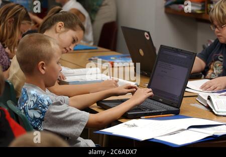 Gun Barrel City, Texas septembre 9, 2003 : les étudiants utilisant des ordinateurs portables sans fil pendant la leçon de science dans la classe de 5e année tandis que d'autres écrivent dans leurs cahiers d'exercices. ©Bob Daemmrich Banque D'Images