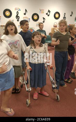 Gun Barrel City, Texas 9 septembre 2003 : une fille handicapée physique avec paralysie cérébrale qui utilise un marcheur danse avec ses camarades de classe de cinquième année pendant le cours d'appréciation de la musique. L'école intègre ses élèves handicapés, les plaçant avec des élèves normalement capables dans tous les contextes scolaires. LIBÉRATION DU MODÈLE SP70 (fille avec marcheur), autres non libérés. ©Bob Daemmrich Banque D'Images