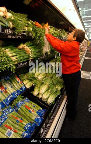 San Antonio, Texas, États-Unis, 21 janvier 2004 : une cliente cherche des carottes fraîches dans la section fruits et légumes du rayon épicerie du magasin Walmart récemment ouvert. ©Bob Daemmrich Banque D'Images