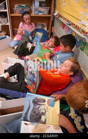 Austin Texas États-Unis, mai 2004 : garçons et filles de première année assis dans des chaises de sac de haricots pendant le temps de lecture indépendant dans leur classe d'école publique. ©Bob Daemmrich Banque D'Images