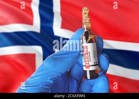 Drapeau des îles Bouvet avec le concept Covid-19 du coronavirus. Un médecin portant des gants médicaux de protection bleus tient un flacon de vaccin. Coronavirus covid 19 Banque D'Images