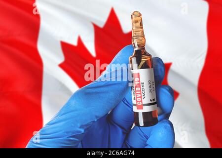 Drapeau canadien avec le concept Covid-19 du coronavirus. Un médecin portant des gants de protection bleus tient une bouteille de vaccin. Coronavirus covid 19 vaccin SPC Banque D'Images