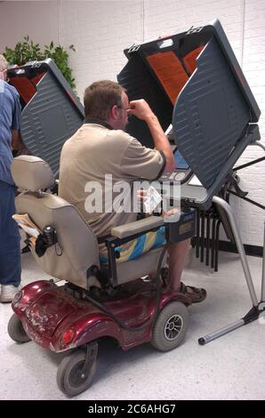 Austin, Texas États-Unis, 19 octobre 2004: Les électeurs précoces du Rebekah Baines Johnson (RBJ) Retirement Centre, un assis sur un fauteuil roulant motorisé devant un système de vote électronique, ont voté à l'élection générale de 2 novembre. ©Bob Daemmrich Banque D'Images