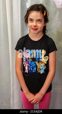 fille de 8 ans regardant vers le haut avec un sourire sur son visage Banque D'Images