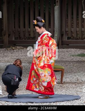 Belle mariée japonaise dans un kimono rouge au sanctuaire Meiji Jingu Shinto, Tokyo, Japon Banque D'Images