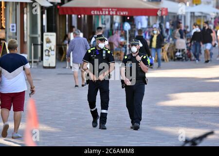 Deux policiers locaux de Calafell City se promènent le long de la rue Paseo Maritimo tout en portant des masques de protection contre la propagation du cavid 19.le Gouvernement catalan ordonne un ordre et oblige les citoyens à porter un masque facial dans les espaces publics, À l'intérieur comme à l'extérieur, bien que la distance de sécurité soit respectée le lendemain, dans le but d'éviter de nouvelles infections du virus Covid-19 comme celle qui affecte Segrià (Lleida). Banque D'Images