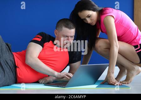 Le formateur présente des exercices à l'étudiant sur un ordinateur portable. Banque D'Images