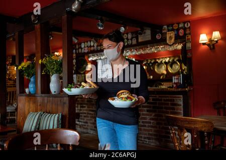 The Crown Pub Little Walden Essex, Royaume-Uni. 8 juillet 2020. Premier jour d'ouverture après plus de trois mois de verrouillage en raison d'une pandémie de coronavirus. Le personnel doit servir de la nourriture et des boissons en portant des masques EPI. Crédit : BRIAN HARRIS/Alay Live News Banque D'Images