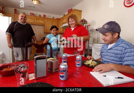 Monte Alto, Texas États-Unis, décembre 11 2004 : la famille Villalpando dans la cuisine de leur modeste maison de trois chambres et une salle de bains financée par Proyecto Azteca, un programme d'aide au logement qui exige des familles de faire du bénévolat en échange de l'achat d'une maison bon marché. Modèle libéré ©Bob Daemmrich Banque D'Images