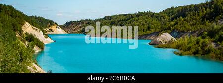 Lac inhabituel avec eau turquoise dans le cratère. Carrière de craie de la côte rocheuse au Bélarus. Jour d'été ensoleillé. Banque D'Images