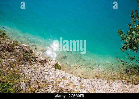 Magnifique paysage de montagne - un lac avec une eau turquoise inhabituelle dans le cratère. Carrière de craie en Biélorussie. Jour d'été ensoleillé. Banque D'Images