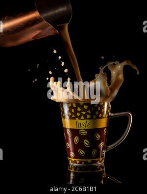 Photographie au flash à grande vitesse avec du café éclaboussant dans la tasse Banque D'Images