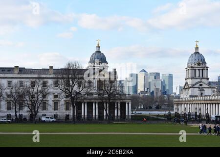 Deux des bâtiments en dôme de l'Old Royal Naval College, qui ont vue à travers les bâtiments jusqu'au quartier des affaires de Canary Wharf, de l'autre côté de la Tamise. Banque D'Images