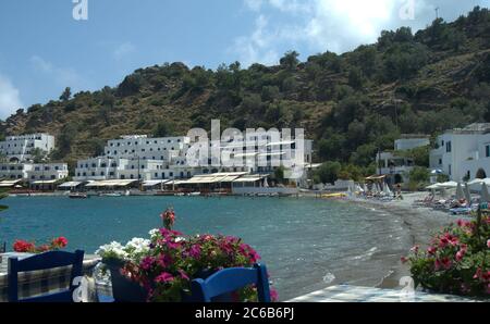 Loutro, Crète, Grèce. Jolie plage avec des tavernes et des bars le long du port. Les vacanciers se détendent au soleil. Banque D'Images
