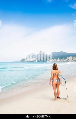 Une femme sportive surfeuse dans un bikini sur la plage d'Ipanema, Rio de Janeiro, Brésil, Amérique du Sud Banque D'Images