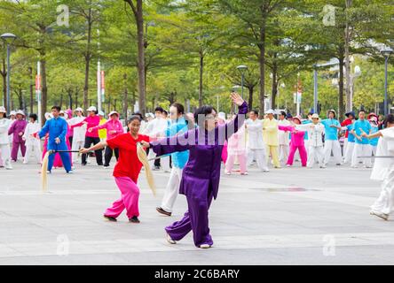 Shenzhen, Chine - 14 novembre 2015 : un groupe de retraités pratiquent la danse d'art martial dans la rue. C'est une sp. Traditionnelle et populaire Banque D'Images