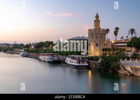 Coucher de soleil à Torre del Oro (Tour d'Or), tour de guet sur la rive du fleuve Guadalquivir à Séville, Andalousie, Espagne, Europe Banque D'Images