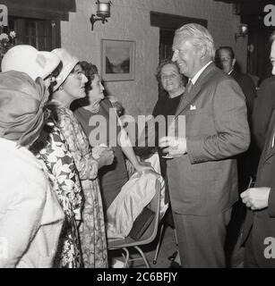 Années 1960, historique, chef du Parti conservateur - de 1965 à 1975 - Ted Heath parlant à des dames bien habillées lors d'une fonction sociale, Angleterre, Royaume-Uni. Heath, originaire de Broadstairs dans le Kent et éduqué au Balloil College, a été député pendant 51 ans, chef de l'opposition en 1975 et Premier ministre du Royaume-Uni entre 1970 et 1974. Banque D'Images