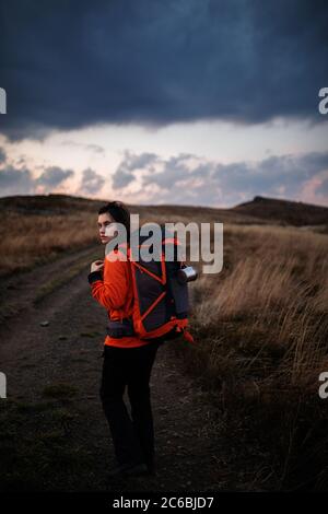 Photo d'une jeune femme regardant le paysage tout en randonnée dans les montagnes. Fille touriste en montagne. Loisirs et santé Banque D'Images