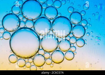 Résumé fond des bulles d'huile sur la surface de l'eau couleur cyan orange. Gros plan macro. Banque D'Images