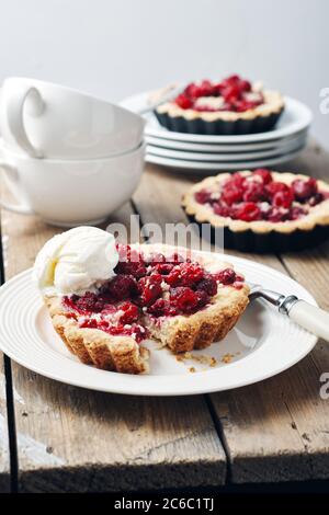 Mini-chaussons cuits aux framboises sur une table rustique en bois. Banque D'Images