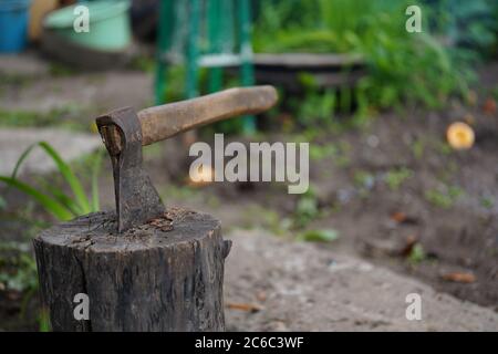 Gros plan de la hache collée dans la souche. Instrument lourd pour hacher le bois. Banque D'Images