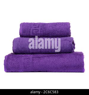 3 serviettes de bain couleur violet, serviette de chambre blanche à l'arrière. Serviettes de bain colorées violets isolées sur blanc. Empiler les serviettes de violettete. Serviettes de couleur velours Banque D'Images