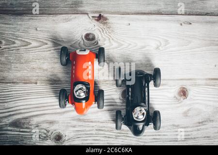 Voitures jouets vintage rouges et noires sur une surface en bois Banque D'Images