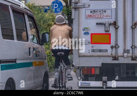 Homme à vélo dans le quartier de Minato, Tokyo, Japon Banque D'Images