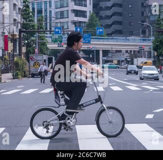 Homme à vélo dans le quartier de Minato, Tokyo, Japon Banque D'Images