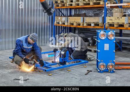 Saint-Pétersbourg, Russie - 24 décembre 2018 : usine de métallurgie, soudeur et broyeur travaillent à la fabrication de produits. Banque D'Images