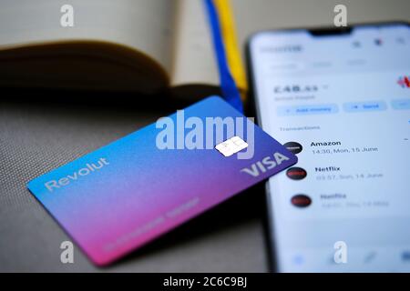 Stone / UK - juillet 8 2020 : nouvelle carte Revolut Bank repensée placée sur le dessus du smartphone avec application Revolut montrant l'équilibre à l'écran. Sélectif f Banque D'Images