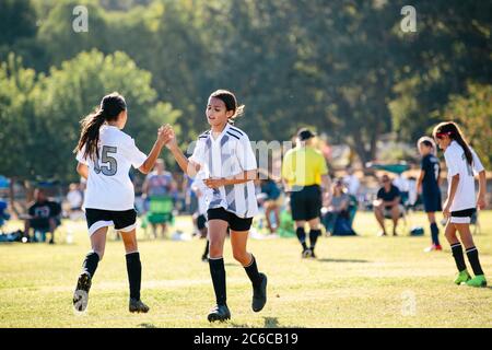 Une fille de joueur de football donne à son coéquipier un haut cinq Banque D'Images