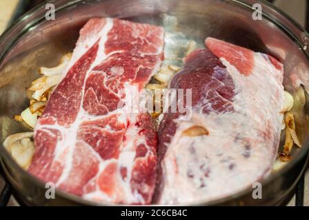 Steaks de bœuf cuits dans la poêle avec des oignons, des pommes de terre andines, des herbes fines et des épices. Banque D'Images