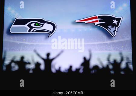 Seattle Seahawks contre .New England Patriots. Assistance pour les fans sur NFL Game. Silhouette des supporters, grand écran avec deux rivaux en arrière-plan. Banque D'Images