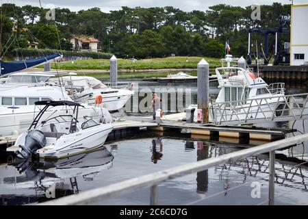 Capbreton, France - 19 juin 2018 : bateaux amarrés et portuaires. Des hommes sur la jetée près du bateau à moteur et des yachts de plaisance. Port sur la côte Atlantique sur une cl Banque D'Images