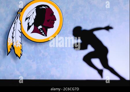 Redskins de Washington. Silhouette de joueur de football américain professionnel. Logo du club NFL en arrière-plan, espace de montage. Banque D'Images