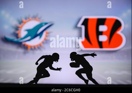 Dolphins de Miami contre Bengals de Cincinnati. Affiche NFL Match. Deux joueurs de football américain se font face sur le terrain. Logo des clubs dans le back-gr Banque D'Images