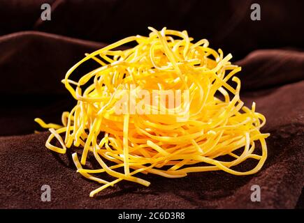 Fettuccine non cuite sur fond coloré Banque D'Images