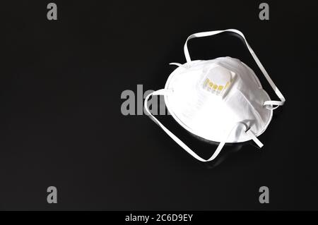 Ensemble de masques blancs sur fond noir. Respirateur avec valve de ventilation, masque anti-aérosol efficace pour la protection contre les agents biologiques Banque D'Images