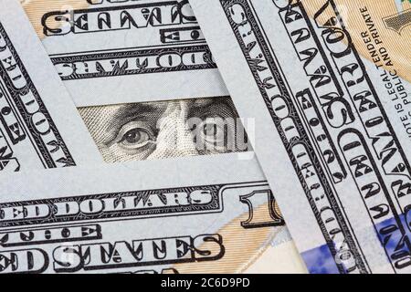 Les yeux de Benjamin Franklin entre des billets de cent dollars Banque D'Images