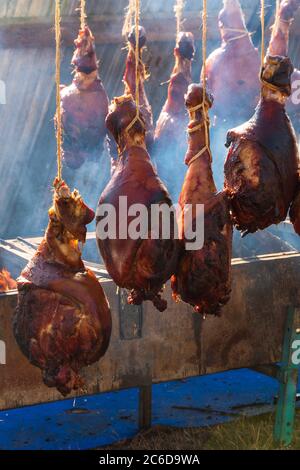 Des pattes de porc rôties au feu ouvert lors d'un festival gastronomique en Bretagne, en France, en été ensoleillé. Banque D'Images