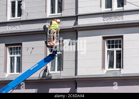 Riga, Lettonie - 3 juillet 2020 : un ouvrier de construction sur une plateforme de levage hydraulique inspecte l'état des tuyaux d'égout Banque D'Images